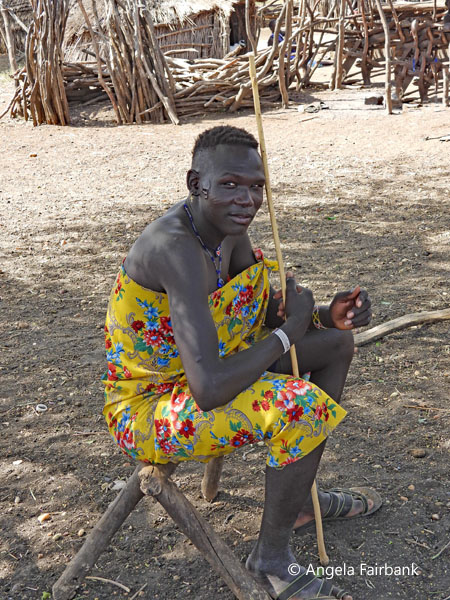 young Toposa man in yellow seated