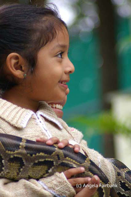 girl in white holding large snake 1