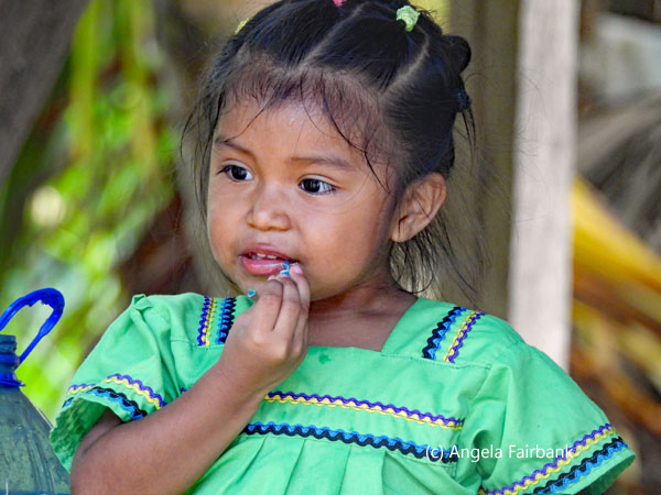 girl in green picking teeth