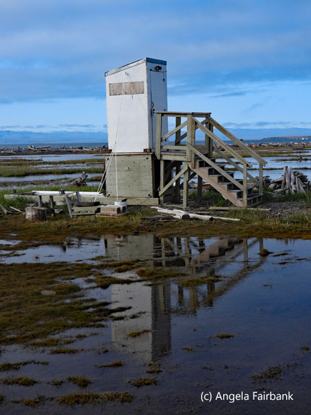 outhouse reflected in water